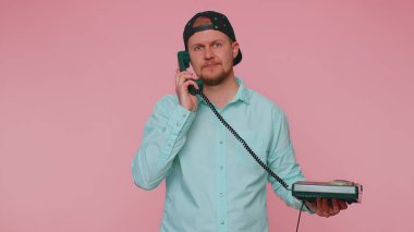 Neşeli turist sekreteri 80 'lerin telli vintage telefonundan konuşuyor.