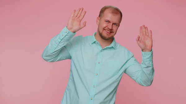 Barbudo hombre sonriendo amigable a la cámara y saludando con las manos señalando hola o adiós, dando la bienvenida — Foto de Stock