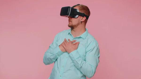Hombre usando la tecnología futurista de realidad virtual casco de auriculares VR para jugar simulación videojuego 3D —  Fotos de Stock