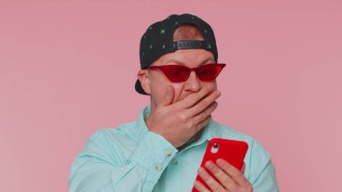 Endişeli komik bağımlı turist hevesle cep telefonuyla yarış oyunları oynuyor.