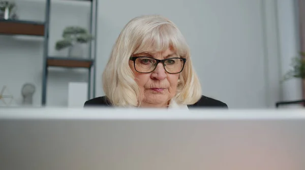 Senior business woman freelancer using laptop computer sits at workplace typing browsing at office — Stock Photo, Image