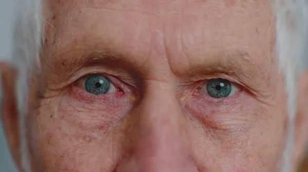 Extreme close-up macro portrait of wrinkled face, old senior beautiful mans eyes looking at camera — Stock Photo, Image