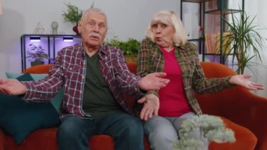 Yaşlı aile büyükbabaları erkek kadın kızgın bir ifadeyle ellerini kaldırarak, neden, hangi başarısızlığın sebebini sorarak, sorunlardan kuşkulandığını gösteriyor. Olgun büyükbaba evde.