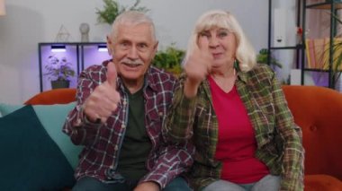 Aferin, aferin. Gururlu yaşlı yaşlı aile çifti, büyükanne ve büyükbaba erkek kadın alkışlıyor ve onaylıyor, başarılı bir iş. Olgun büyükbaba evde kanepede oturuyor.