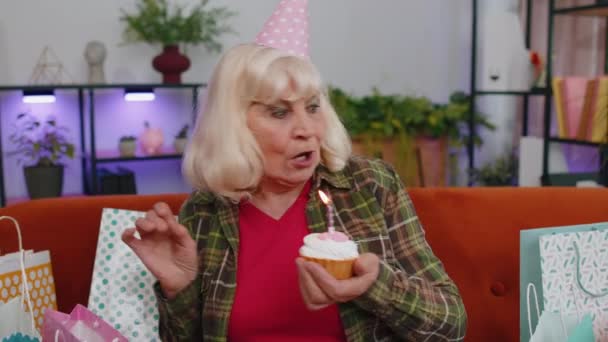 Ευτυχισμένη Ηλικιωμένη Ηλικιωμένη Γυναίκα Φοράει Εορταστικό Καπέλο Που Κρατά Cupcake — Αρχείο Βίντεο