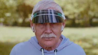 Atletik spor koşucusunun portresi kulaklık takıyor müzik dinliyor, gülümsüyor, kardiyo yapıyor.