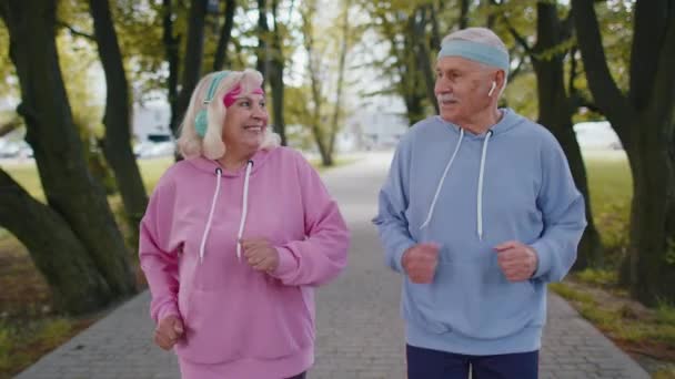 Atletisk fitness senior äldre sport löpare man kvinna utbildning cardio träning i parken på morgonen — Stockvideo