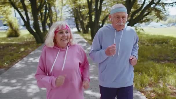 Fatigué grand-père épuisé, grand-mère se détendre après difficile course longue distance dans le parc — Video