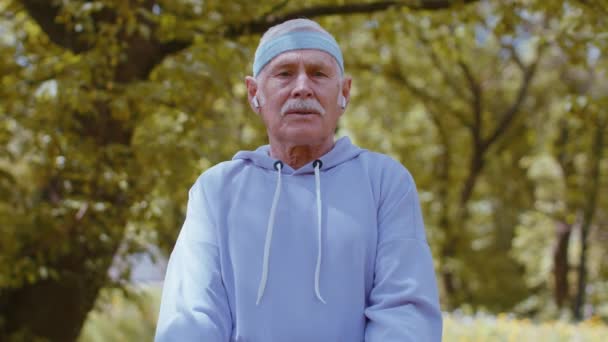 Старший мужчина упражнения, делая гантели тяжести упражнения, практикуя спортивные тренировки в парке — стоковое видео