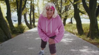 Atletik fitness son sınıf spor koşucusu kadın büyükannem sabah parkta egzersiz yapıyor.