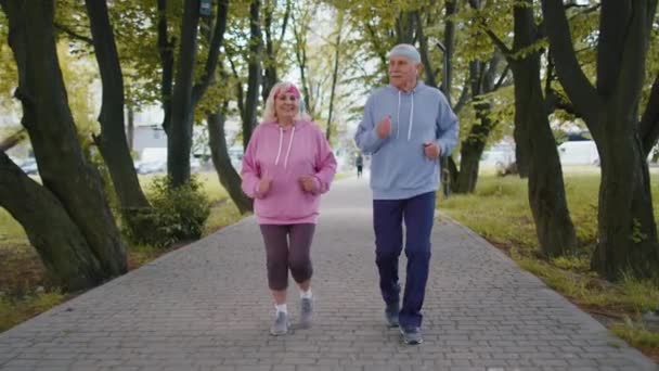 Atletische fitness oudere sport loper man vrouw training cardiotraining in het park 's morgens — Stockvideo