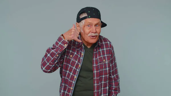 Cheerful senior man in shirt looking at camera doing phone gesture like says hey you call me back — Stock Photo, Image