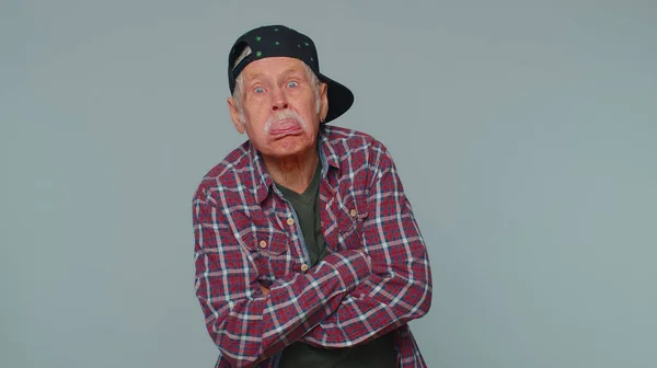 Zabawny człowiek pokazuje język robiący miny przed kamerą, wygłupiający się, żartujący, małpujący głupią twarzą — Zdjęcie stockowe