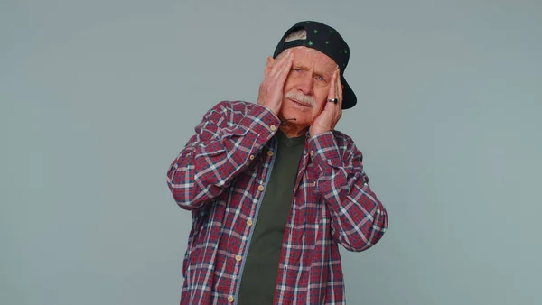 Senior man rubbing temples to cure headache problem, suffering from tension and migaine, stress pain — Fotografia de Stock