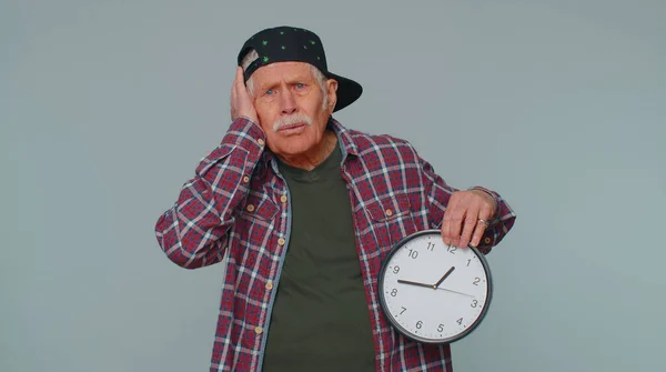 Confused senior man with anxiety checking time on clock running late to work being in delay deadline — ストック写真