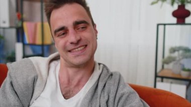 Yakışıklı, mutlu, Kafkasyalı, şanslı, güler yüzlü, güler yüzlü, mutlu, yüzünü çeviren, rüya gören, rahatlayan, tatmin olmuş konsepti olan, sınıf odasındaki kanepede oturan iyi haber.