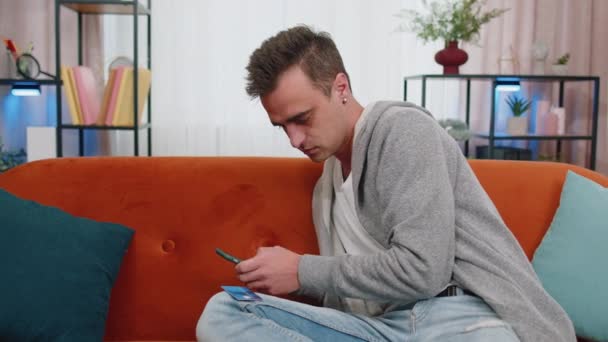 Leende Vit Ung Vuxen Man Sitter Soffan Med Kreditkort Och — Stockvideo