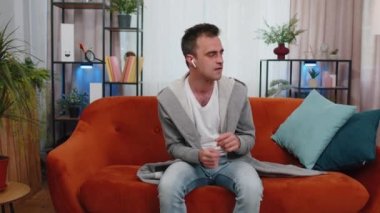 Evdeki koltukta dans eden, kablosuz kulaklıklı mutlu, gevşemiş adam akıllı telefondan en sevilen disko rock 'n roll müziğini dinliyor ve içeride eğleniyor. İnsanlar hafta sonu aktiviteleri