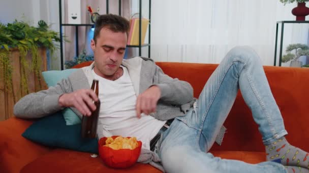 Bell Uomo Seduto Sul Divano Che Mangia Patatine Fritte Beve — Video Stock