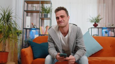 Heyecanlı beyaz bir adam cep telefonuyla yazı yazarak 