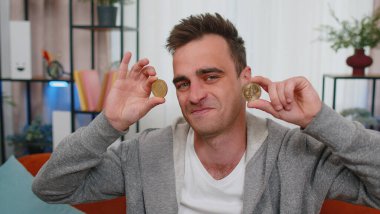 Evde iki altın sikke tutan serbest çalışan başarılı bir programcı. Hisse senedi tüccarı, online ticaret operasyonlarını izledikten sonra bitcoin kazanıyor. Artan zenginlik, artan mali refah