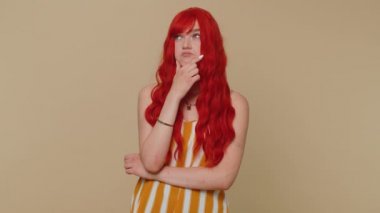 Evreka. Askılı tişörtlü kızıl saçlı kadın ağzını açıp Eureka 'ya çözüm jesti, ilham, cevap veriyor. Genç yetişkin bir kız bej renkli stüdyo arka planında tek başına izole edilmiş.