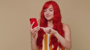 Çizgili kolsuz bluzlu mutlu bir kadın cep telefonu kullanıyor. 