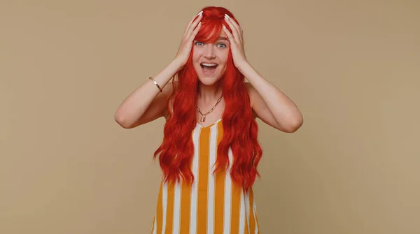 Redhead woman in tank top screams from stress tension problems feels horror hopelessness fear surprise shock expresses gestures rage. Young ginger girl isolated alone on beige studio wall background