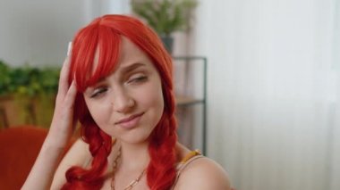 Evinde oturan üzgün, genç, kızıl saçlı kadının yakın çekimi hayat endişelerini ya da karşılıksız aşkı düşünerek adaletsiz bir durumdan muzdarip görünüyor. Sorun, ayrılık, depresif, sinirli, bitkin