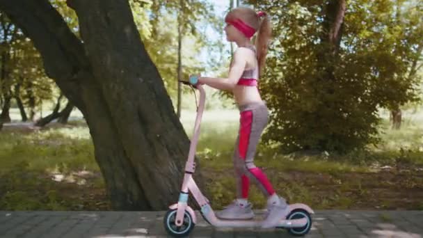 Ung Atletisk Passform Blond Flicka Rider Elektrisk Skoter Väg Parken — Stockvideo