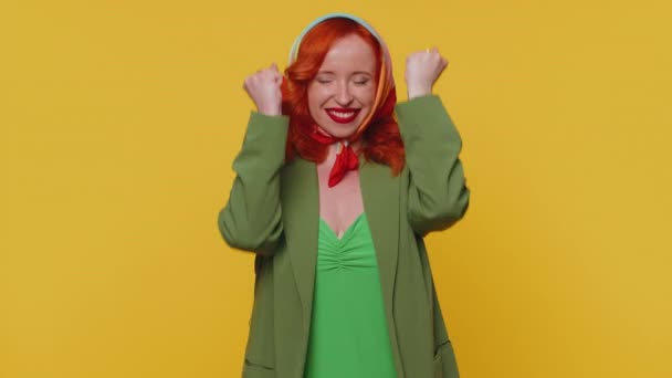 ジャケットやドレス叫んで幸せな赤毛の女性 ジェスチャーで拳を上げる私はそれをやった 成功を祝う 誕生日 宝くじ目標達成者 若いです女の子屋内で黄色のスタジオの壁の背景 — ストック動画