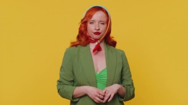 Komik, neşeli, samimi, yirmili yaşlarda, ceketli, komik, komik yüz ifadeleri yapan, suratını buruşturan, dil gösteren kızıl saçlı bir kadın. Genç, güzel, kızıl kız, sarı arka planda tek başına.