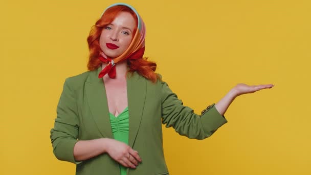 親指を表示し 空の場所を指す美しい赤毛の女性は 商業テキストの広告エリア 商品プロモーションのためのスペースをコピーします 若い生姜娘 黄色の背景で撮影された屋内スタジオ — ストック動画