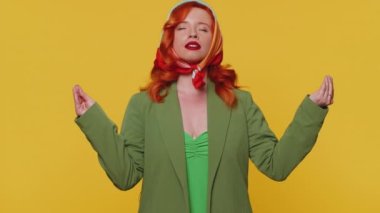 Sakin ol, rahatla, iç denge. Kadın derin derin nefes alıyor, gözleri kapalı konsantre düşüncelerle meditasyon yapıyor huzurlu zihinle. Kızıl saçlı yetişkin kız sarı stüdyo arka planında izole edilmiş.