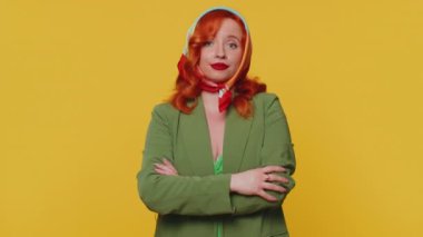 Sevimli, neşeli kızıl kadın önerini çok beğeniyor. Başını sallıyor, güzel bir işten memnun, evlenme teklifi gibi. Sarı stüdyo arka planında izole edilmiş genç bir kızıl kız.