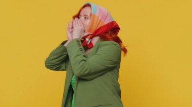 Ağız kenarında el ele tutuşan etkileyici bir kadın yüksek sesle bağırıyor, bağırıyor, bağırıyor, indirim duyurusu yapıyor. Genç kızıl saçlı kız sarı stüdyo geçmişinde tek başına izole edilmiş.