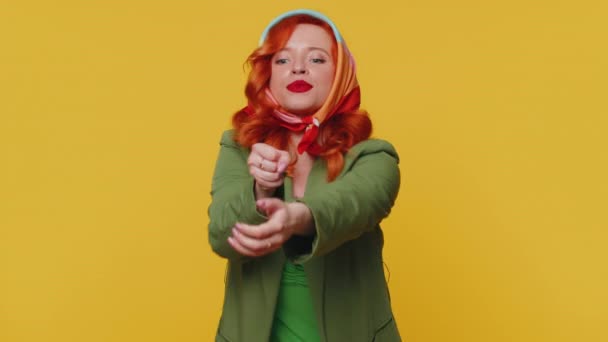 混杂着红头发的女人穿着夹克拉着一根假想的虚幻无形的绳子 花了很大的力气来展示她是多么的持久 年轻的姜姑娘孤身一人被隔离在黄色的工作室墙壁后面 — 图库视频影像
