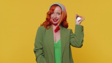 Kızıl saçlı genç emlakçı kadın yeni ev dairesinin anahtarlarını gösteriyor, mülk alıyor ya da kiralıyor, ipotek kredisi veriyor. Kızıl saçlı kızıl kız sarı stüdyo arka planında izole edilmiş.