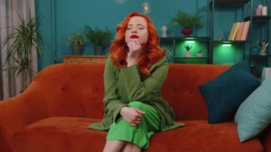 Evreka. Düşünceli, zeki, ilham verici kızıl saçlı genç kadın parmağını kaldırdı yaratıcı bir plan yaptı. İyi fikirle heyecanlandı, ilham kaynağı oldu. Kızıl kız evde, oturma odasında.