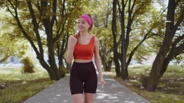 Atletik formda koşucu kız başarıyı kutluyor zafer çığlığı zafer maratonunu kutluyor. Sunny Park 'ta kardiyo eğitimi. Genç bir kadın sağlıklı yaşam tarzını seviyor. Aktif sporcu kadın motivasyonu