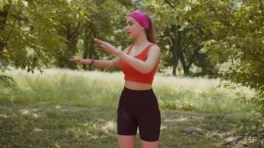 Spor yapan genç bir kadın parkta spor egzersizleri yapıyor. - Ne? Sıska atletik kız güneşli bir günde spor yapıyor. Hafta sonları sporcu kadın antrenmanı var. Sağlıklı yaşam tarzı kavramı