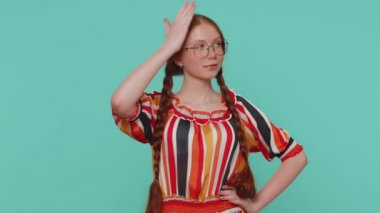 Ben en iyisiyim, beni seç. Kızıl saçlı kız kendini göstermekten gurur duyuyor, kendinden emin görünüyor, başarıdan çok memnun. Genç kızıl çocuk mavi stüdyo arka planında kapalı bir yerde izole edilmiş.