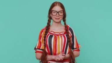 Sevimli, neşeli kızıl kız önerini çok beğendi, başını sallıyor, güzel bir işten memnun, evlenme teklifi gibi. Genç kızıl ergen çocuk mavi stüdyo arka planında izole