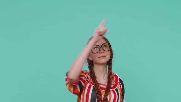 美しい赤毛の女の子の子供が親指を上げて空の場所 商業テキストの広告エリア 商品プロモーションのためのコピースペースを指しています 若いです生姜ティーン子供オンブルースタジオ背景 — ストック動画