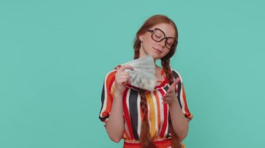 Nakit para bankalarının hayranı kızıl saçlı genç kız dansı, başarılı iş kariyerini, piyango kazananını, büyük geliri ve serveti kutluyor. Kızıl saçlı genç çocuk mavi stüdyoda tek başına.