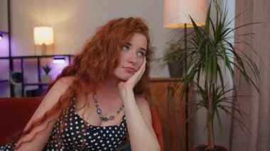 Evinde oturan üzgün, genç, kızıl saçlı kadının yakın çekimi hayat endişelerini ya da karşılıksız aşkı düşünerek adaletsiz bir durumdan muzdarip görünüyor. Sorun, ayrılık, depresif, sinirli, bitkin