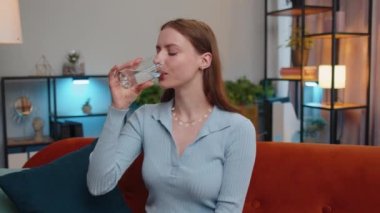 Susamış genç bir kadının portresi, elinde bir bardak su tutarak susuzluğu önleyen bir yudum su içiriyor. İyi yaşam alışkanlıkları, sağlıklı zayıflama, kilo verme konsepti olan bir kız.