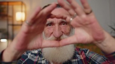 Ben de seni seviyorum. Büyükbaba aşkın sembolünü yapar, kameraya kalp işaretini gösterir, romantik duyguları ifade eder, samimi olumlu duyguları ifade eder. Sadaka, minnettarlık, bağış. Adam yakın plan gülen surat
