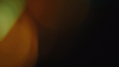 Çok renkli ışık siyah arkaplanda 4K görüntü sızdırıyor. Stüdyoda gaz sızıntısı var. Doğal aydınlatma ışınları bokeh etkisi. Çekimlerinizi birleştirmek, videoyu biçimlendirmek, geçişlerinizi