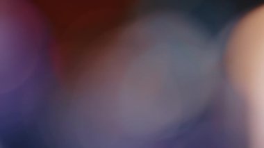 Işık, soyut 4K görüntülerini sızdırır. Yanıp sönen çember mercek parıltısı bokeh, bulanık renk arkaplanının odaklanmamış doğal animasyonunu örtüyor. Çekimleriniz üzerinde birleştirme, videoyu biçimlendirme, geçişler